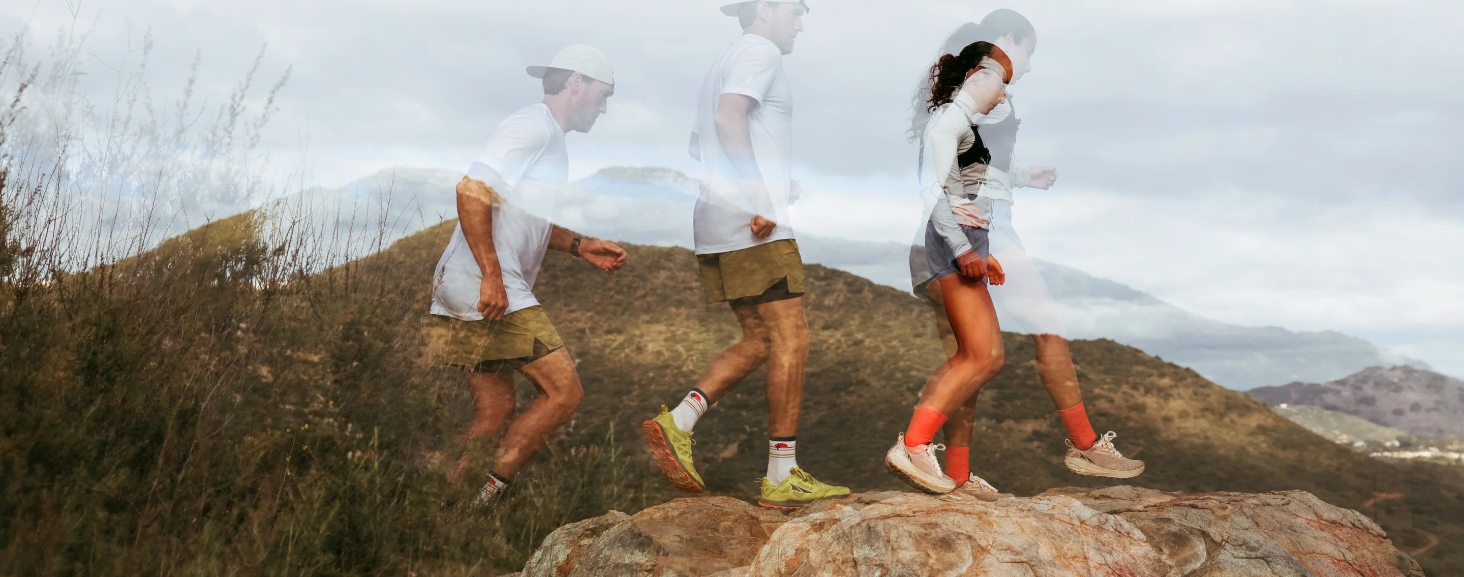 Two runners headed across a rocky trail, showing their motion